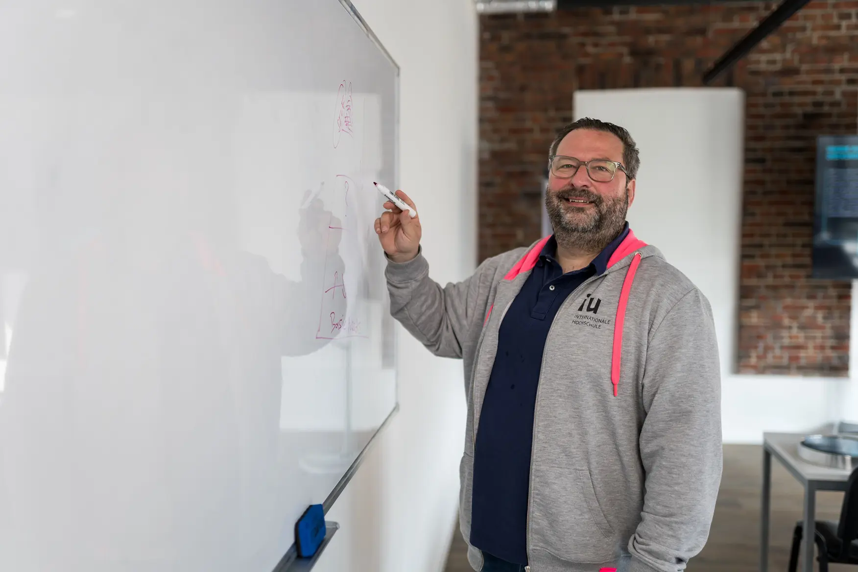 Professor Hoodie teaching whiteboard smiling