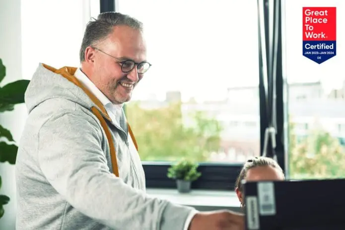 Robert zeigt seinem Kollegen etwas am Laptop
