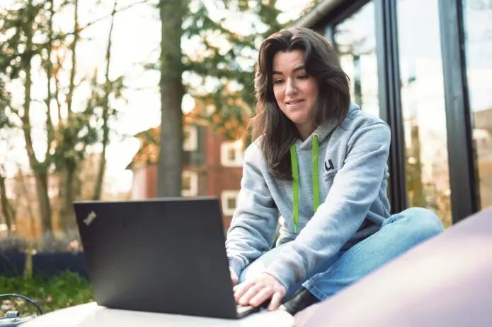 Frau sitzt im Garten und arbeitet