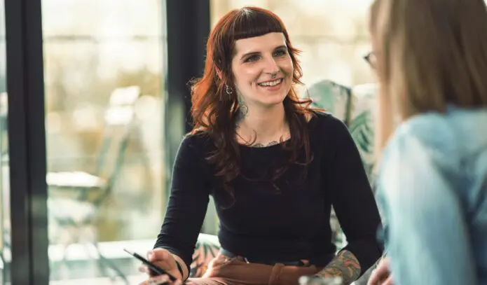 Jana zeigt Amira etwas am Handy zwei Kolleginnen der IU