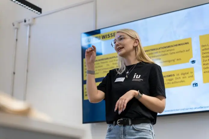 Woman helds presentation in front of students lecturer room
