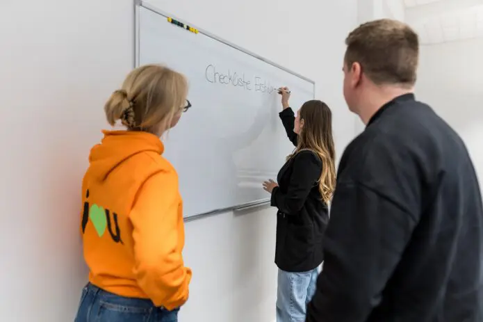 three people whiteboard planning