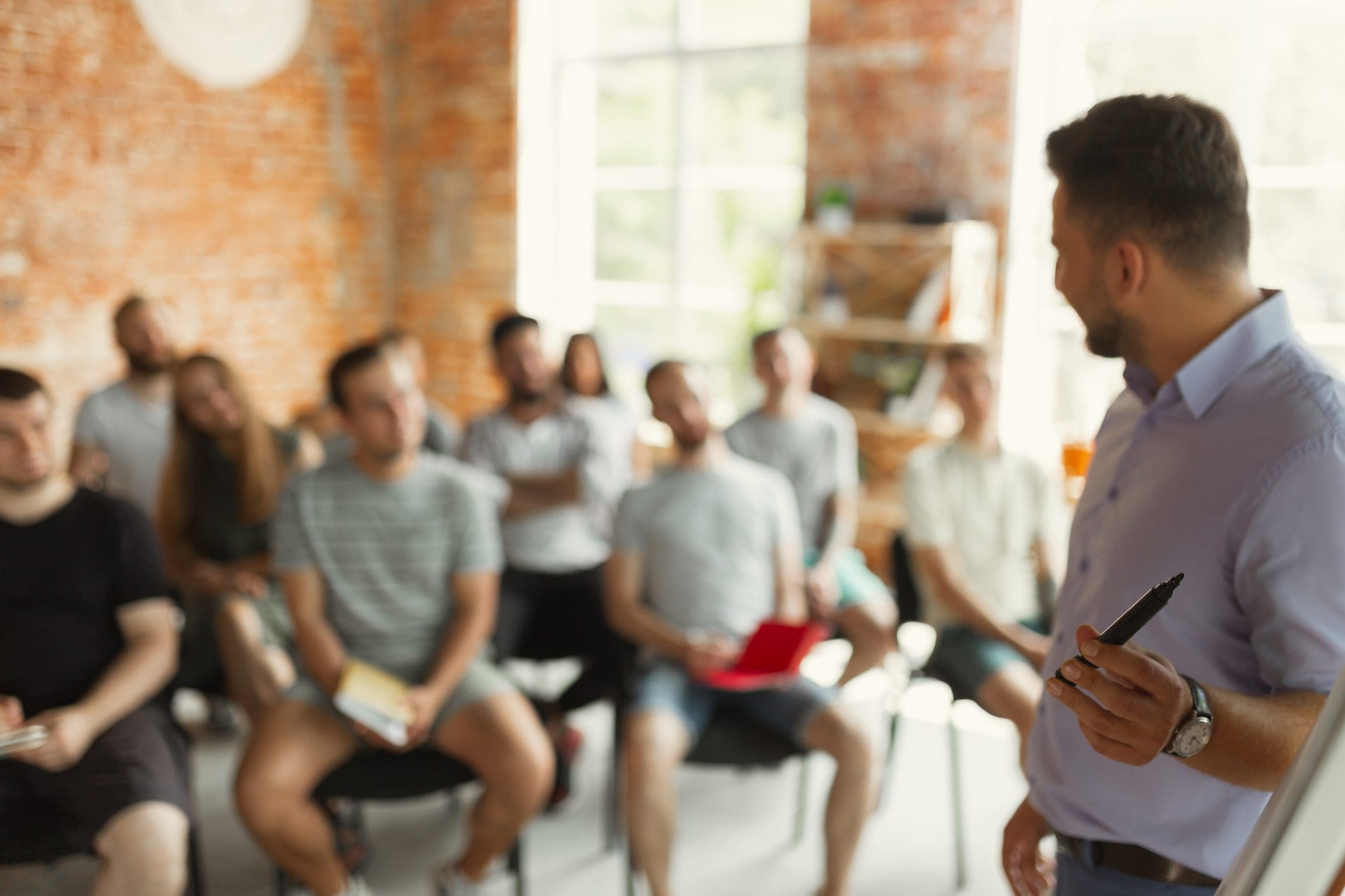 Male speaker giving presentation in hall at university workshop
