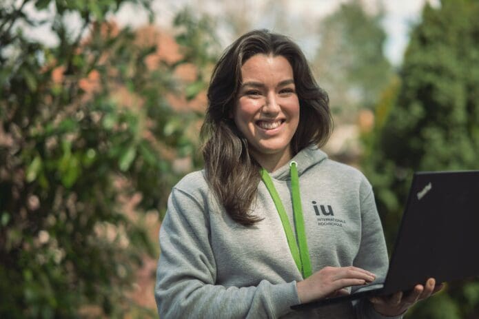 Kollegin steht im Grünen und grinst