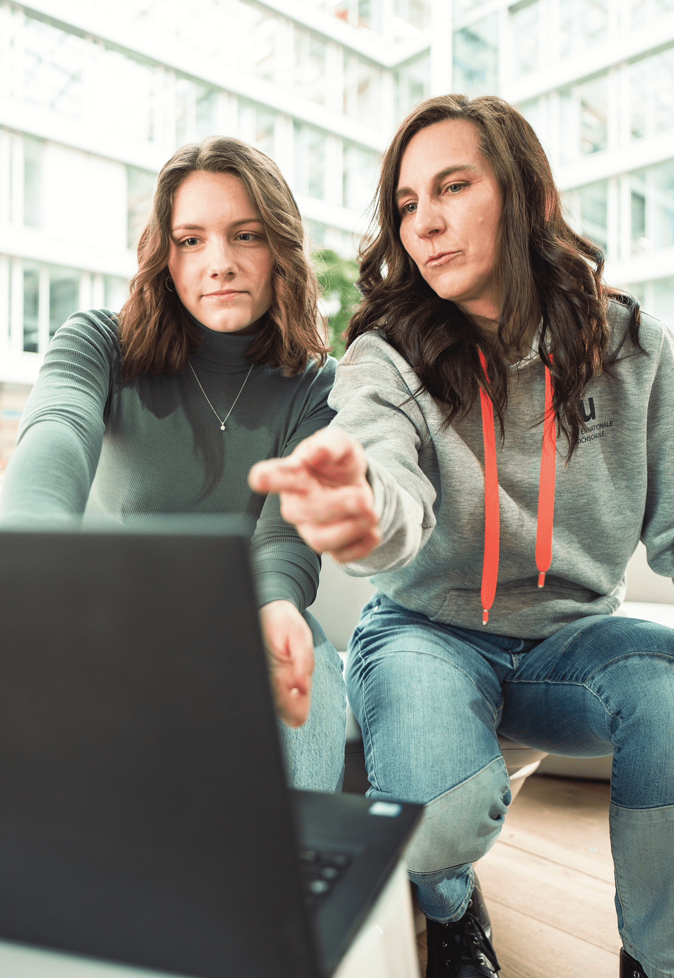 Dozentin zeigt Studentin etwas am Laptop